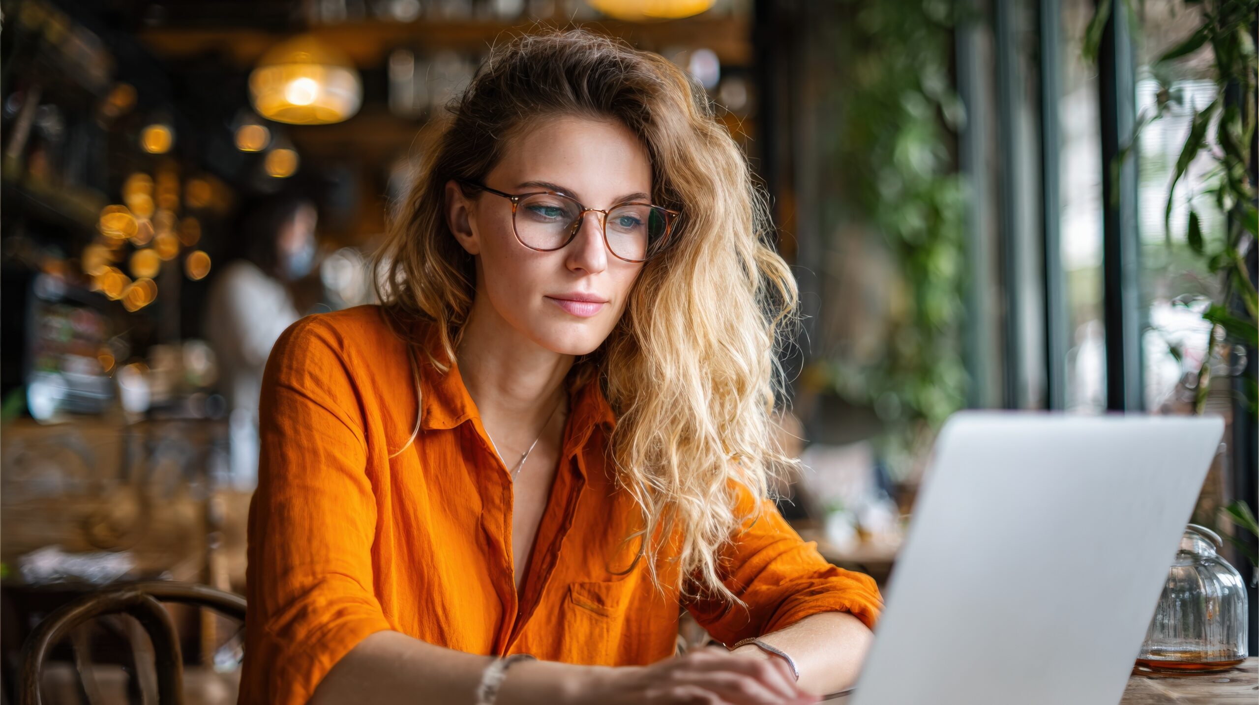 woman with orange shirt typing scaled